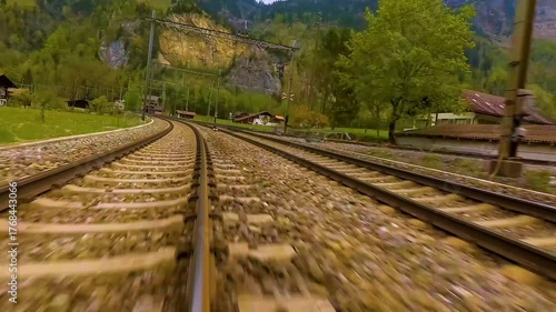 A time lapse low angle view of train tracks riding across the kandertal valley in switzerland on a cloudy day