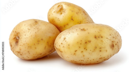 Three fresh raw potatoes with light brown skin and earthy texture isolated on a white background