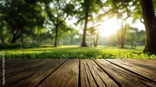 Sunlight filtering through lush green trees in a park with a rustic wooden table in the foreground