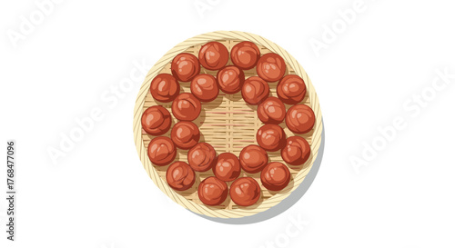 A top-down view of vibrant red umeboshi plums, neatly arranged on a traditional round woven bamboo mat against a white background.
