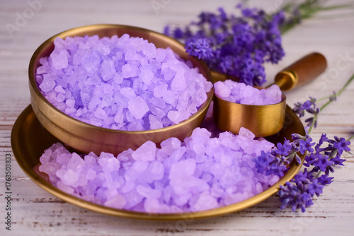 Close-up of fragrant purple bath salts with dry lavender on a metal plate.

