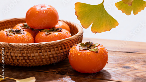 Persimmons in Basket with Leaves