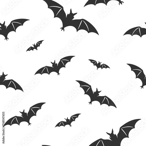 Seamless pattern of flying dark silhouette bats on a white background for halloween and spooky designs