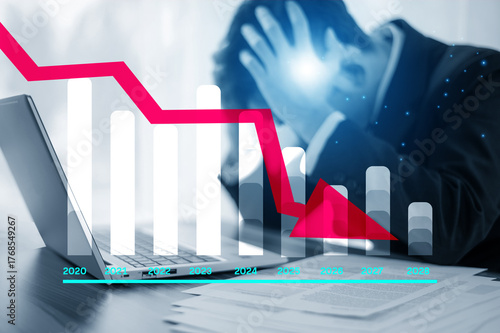 Investor stressed after stock market downturn with laptop and falling graph illustrating business failure and global financial crisis.