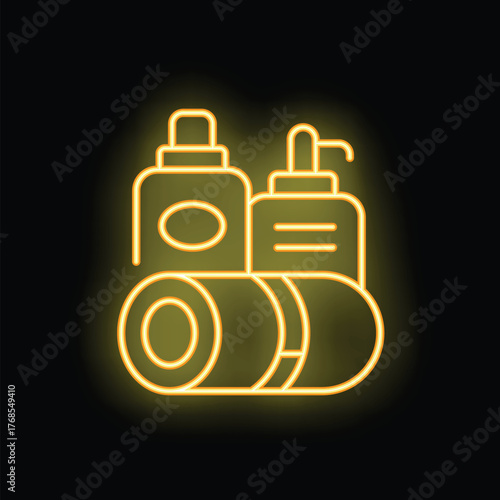 Yellow glowing neon sign of bathroom amenities including towels, shampoo and liquid soap on a black background
