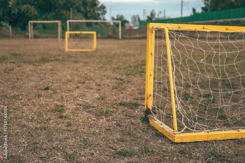 Foto Closeup of worn netting on small mini soccer goal standing on field with patchy