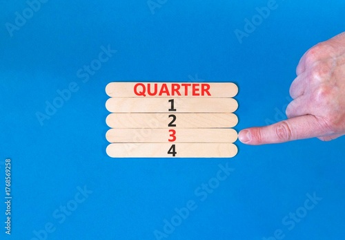 3rd third quarter 3 symbol. Concept word Quarter 3 on beautiful wooden sticks. Beautiful blue background. Businessman's hand. Business, happy 3rd third quarter 3 Q3 concept. Copy space.