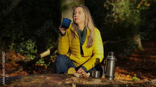 Slavic Woman in Yellow Puffer Jacket Enjoying Hot Drink Outdoors in Forest