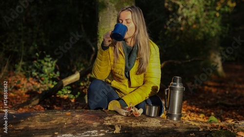 Slavic Woman in Yellow Puffer Jacket Enjoying Hot Drink Outdoors in Forest