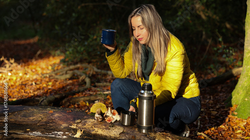 Slavic Woman in Yellow Puffer Jacket Enjoying Hot Drink Outdoors in Forest