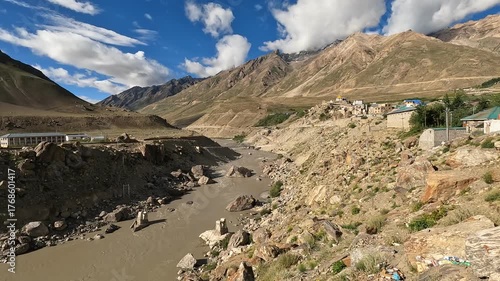 Peaceful morning view of the river flowing around Padum village in Zanskar Valley, Ladakh, India - calm water, mountains, and soft sunrise light.