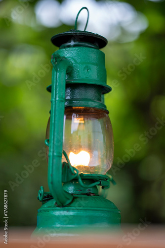 Green kerosene lantern glowing softly outdoors