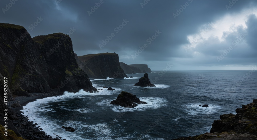 Obraz premium Cold weather, heavy cloudy day over rugged coastline with dark sea and rock formations. Concept of power and immensity of nature.