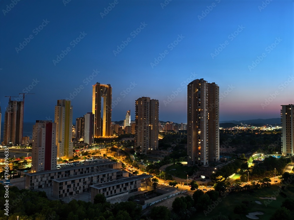 Fototapeta premium A stunning nightscape of urban highrises and illuminated streets full of city life