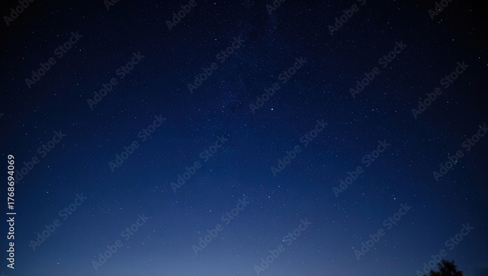 Naklejka premium A serene night sky filled with countless stars, glowing softly against deep blue darkness — peaceful, vast, and perfect for dreams, astronomy, or cosmic themes.