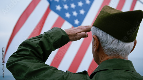 USA Flag Wawing Over The Sea In Front Of A Retired Soldier