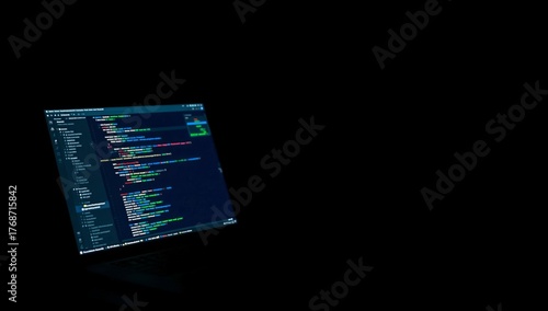 Bright Coding Screen Illuminates Dark Room During Late-Night Programming Session