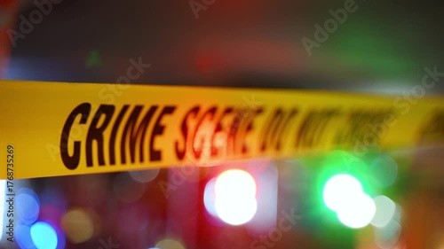 A bright yellow Crime Scene tape across an urban environment, marking a restricted area for investigation. Police or rescue team flashing lights are on the background