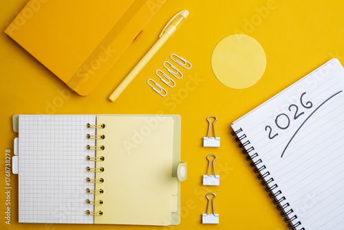 Happy New Year 2026 and a notepad on a colored background. Layout for writing annual business plans, schedules, as well as New Year's resolutions and goals. 