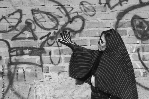 La catrina observando su graffiti en la calle