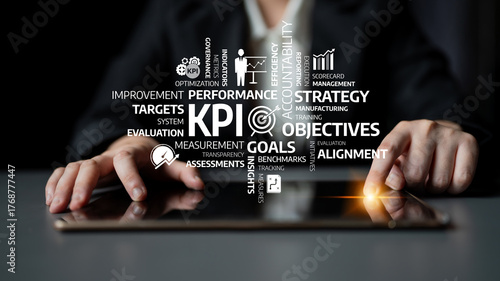 Fotografie A business professional interacts with a digital tablet, focusing on key performance indicators for strategic evaluation and performance enhancement within a corporate environment