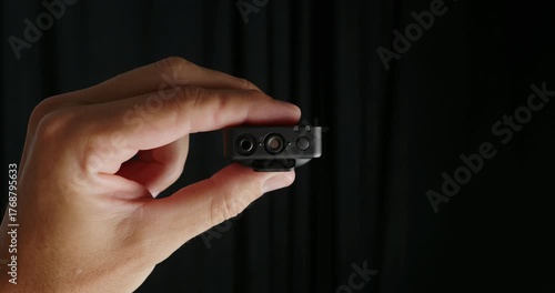 Small wireless microphone in hand recording voice audio.