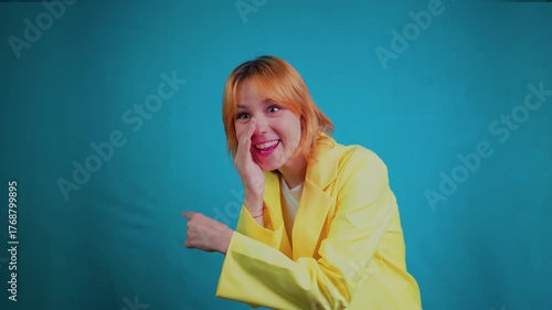 Young woman whispering secret and pointing finger
