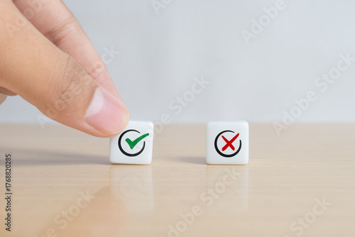 A man choosing between a checkmark and an 'X' symbol on dice. Image represents the concept of making the right choice, highlighting the importance of distinguishing between right and wrong