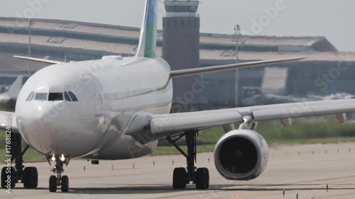 white jumbo jet taxiing inside barelona airport 