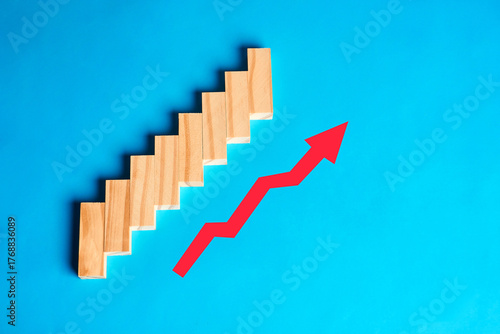 Billede på lærred Rising arrow beside wooden steps, representing growth, performance improvement and stepwise progress toward ambitious goals