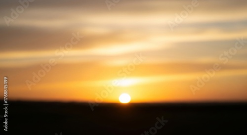 Blurred Sunset with Golden Sky Over Distant Horizon