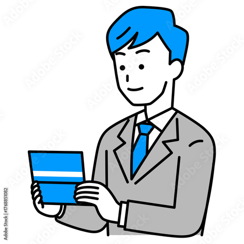 預金通帳を見るスーツの男性