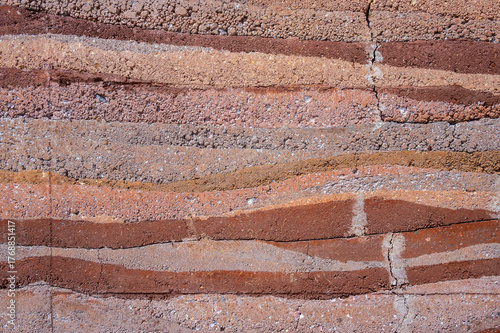 Full frame shot of an earthen wall texture of clay house structure. These walls are constructed by ramming a mixture of aggregates, including gravel, sand, silt and a small amount of clay.