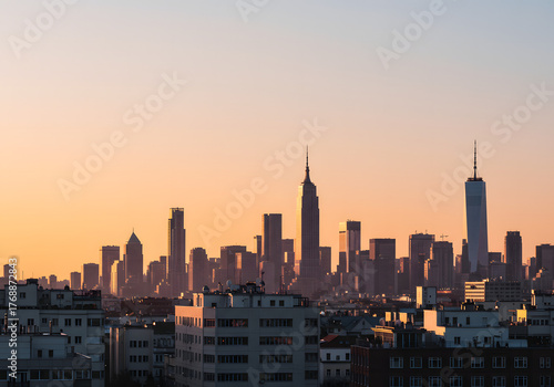 Panoramic view of a bustling metropolitan skyline bathed in the warm glow of dusk, showcasing impressive architecture and the vibrant energy of urban life against a golden sky