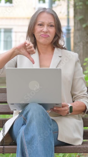 Thumbs Down by Old Senior Woman Using Laptop in Park