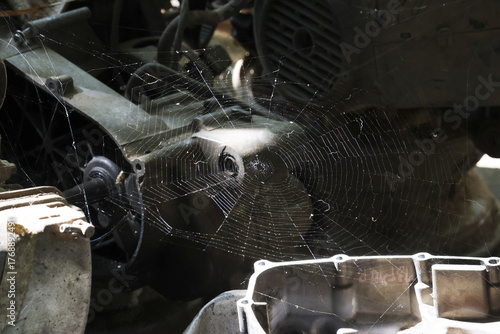 Large spiderweb on an abandoned old engine. dirty mechanical machine part has an industrial grunge feel, representing forgotten and neglected piece of machinery