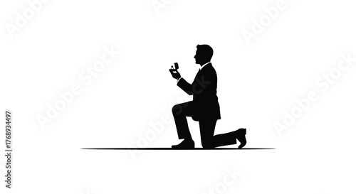 Man in a suit proposing on one knee holding a ring in a striking black silhouette