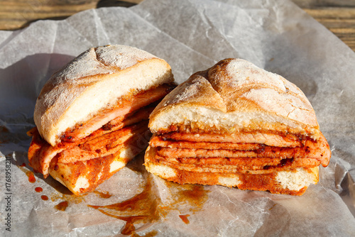 Photos A thick Peameal Bacon sandwich, sliced open to show the many layers of cured pork and sauce