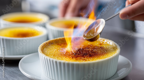 Close-up of chef torching crÃ¨me brÃ»lÃ©e, golden caramel crackling