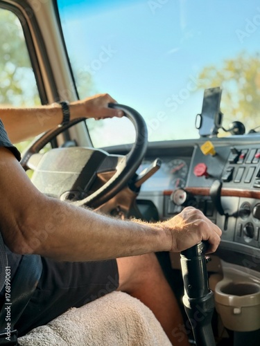  truck driver steers the vehicle with both mittened gloves hands on the steering wheel