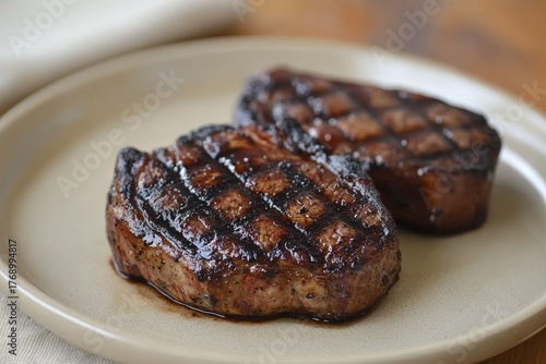 Wallpaper Mural Two grilled steaks sit on a plate, glistening with flavorful brown hues and grill marks. Torontodigital.ca