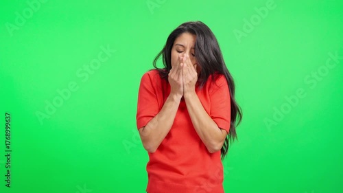 Freezing young woman shivering from cold on green screen