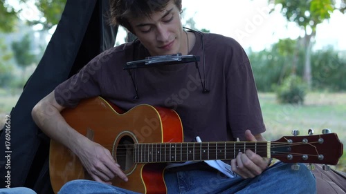 man playing guitar at the park