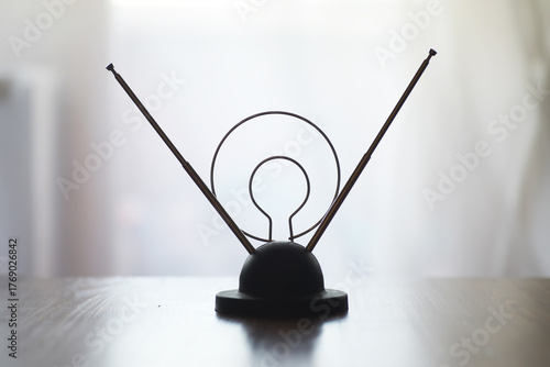 Vintage TV Antenna on Wooden Table with Blurred Background