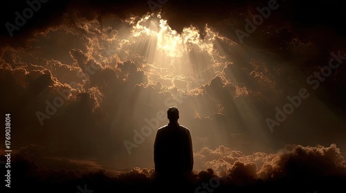 A man walking through a dark valley toward the heavenly concept. A person stands in awe beneath divine light breaking through clouds.