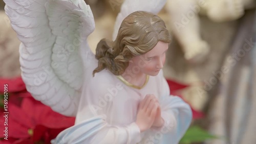 Catholic nativity scene with angels. Christmas religious still life with red flowers prayer and faith detail closeup