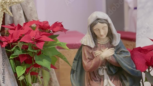 Catholic nativity scene with virgin Mary. Christmas religious still life with red flowers prayer and faith detail closeup