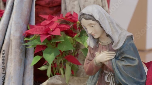 Catholic nativity scene with virgin Mary. Christmas religious still life with red flowers prayer and faith detail closeup