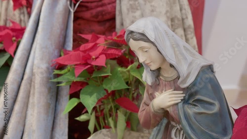 Catholic nativity scene with virgin Mary. Christmas religious still life with red flowers prayer and faith detail closeup