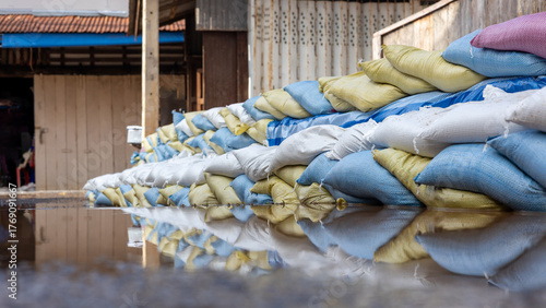 Many sandbags are stacked and reflected in the water.
